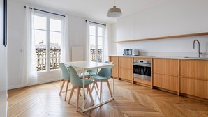 Une cuisine moderne avec des meubles en bois, un plan de travail blanc et un four encastré.