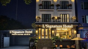 Das L'Signature Hotel mit einem privaten Parkplatz, einem gut beleuchteten Eingang und Außenbestuhlung.