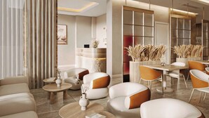 Eine moderne Hotelhalle mit Sofas, Tischen und einer Rezeption.