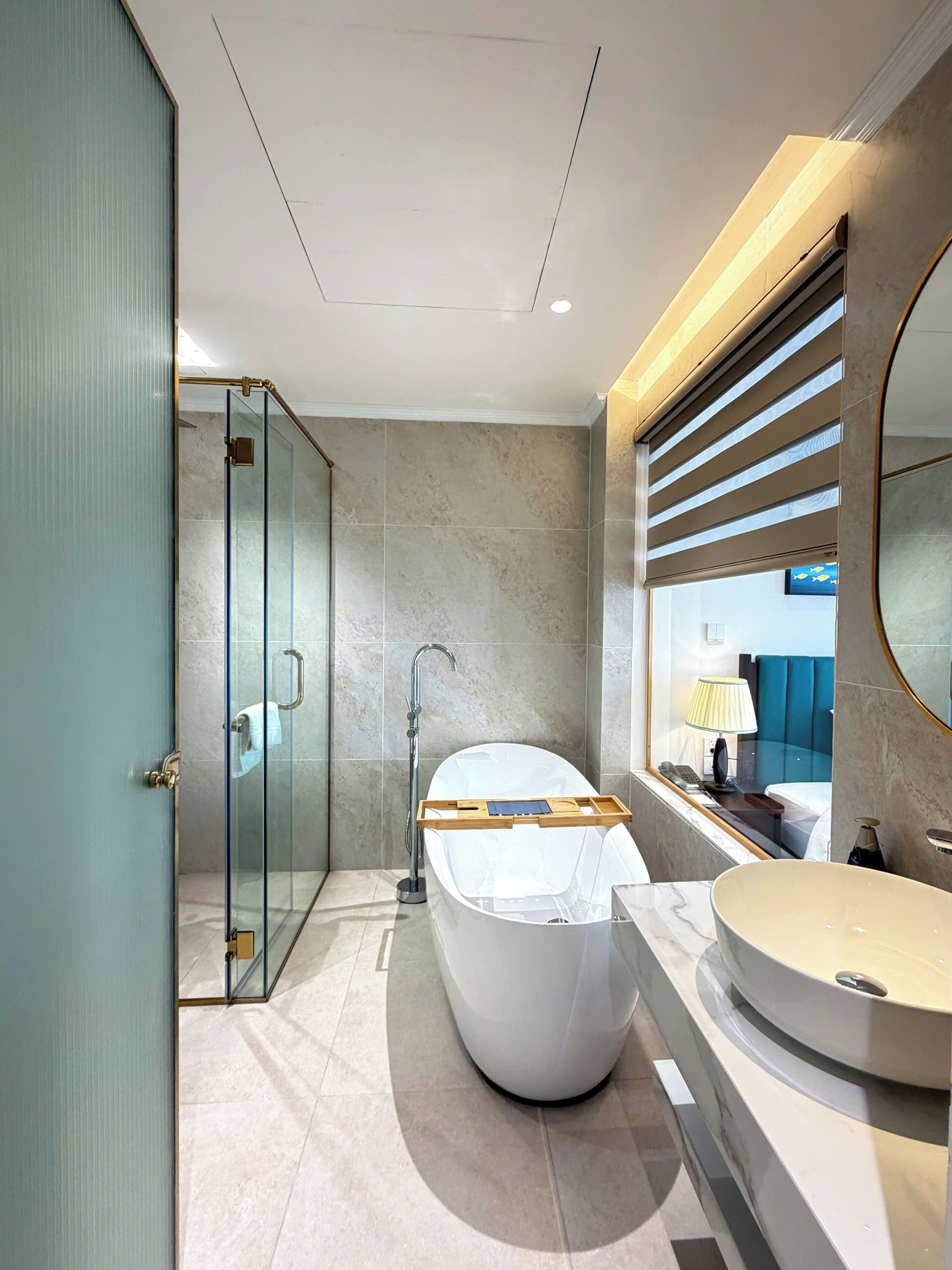 Une salle de bain moderne dotée d’une douche à parois de verre, d’une baignoire sur pieds et d’un meuble-lavabo avec un miroir.