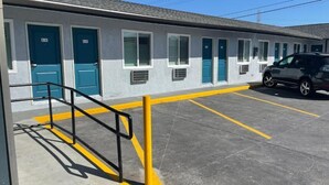 A motel with a row of rooms, a parking lot, and a yellow safety line. - La Palma Motel - South Gate - LA area (South Gate)