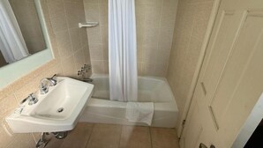 A bathroom with a sink, bathtub, and shower curtain. - El Rancho Motel - Pasadena (Pasadena)