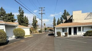 A quiet street with two-story buildings, a clear sky, and power lines. - El Rancho Motel - Pasadena (Pasadena)