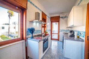 A modern kitchen with a central island, a stove, and a range hood.