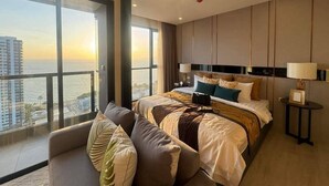 Ein modernes Hotelzimmer mit einem großen Bett, einer Sitzecke und Blick auf die Stadtlandschaft.