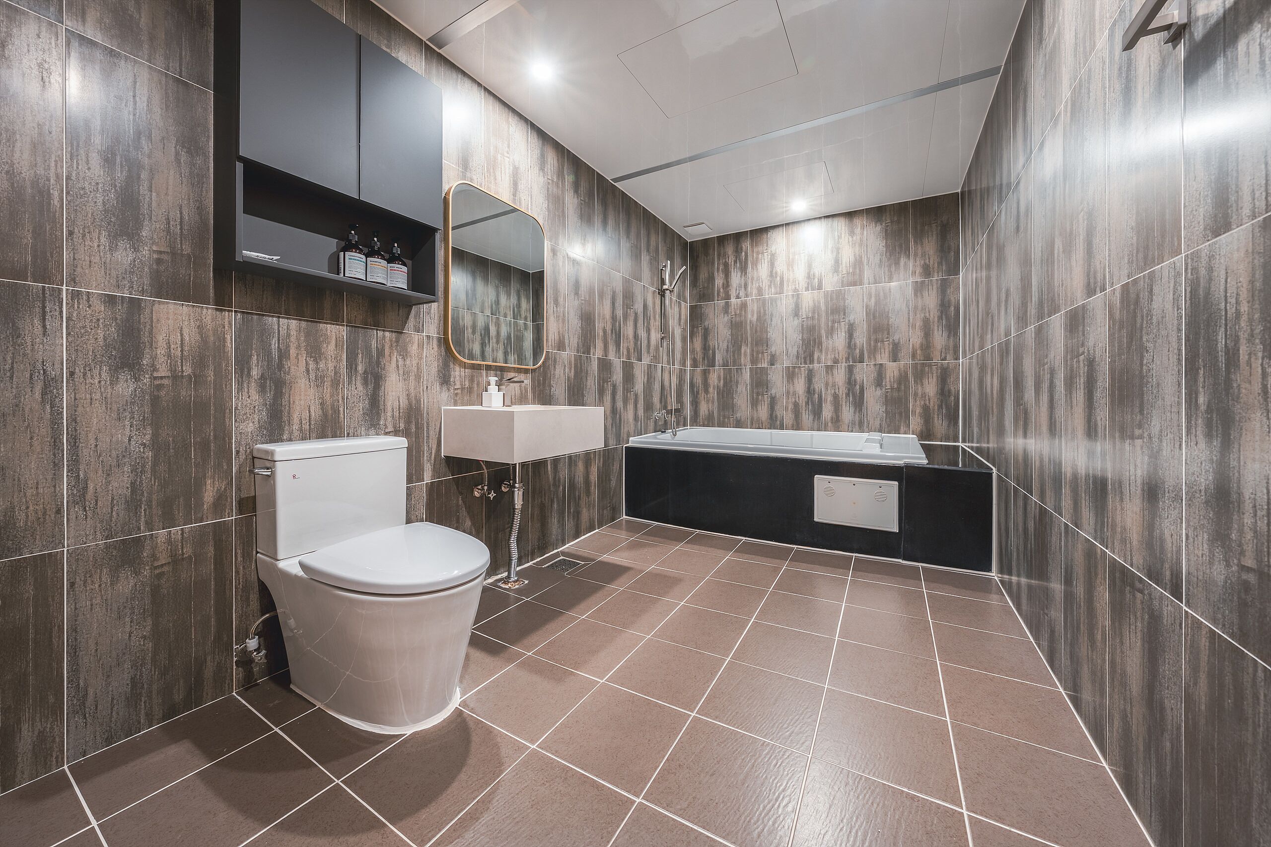A modern bathroom with a toilet, sink, and bathtub.