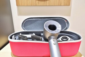 Une trousse de voyage rouge contenant un objet métallique, qui pourrait être un appareil portable.