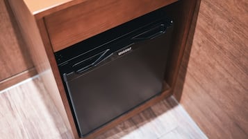 A black dishwasher installed in a wooden cabinet with a handle.