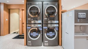 A hotel laundry facility with four washing machines and a refrigerator. - Hotel Coolstay Gimcheon (Gimcheon)