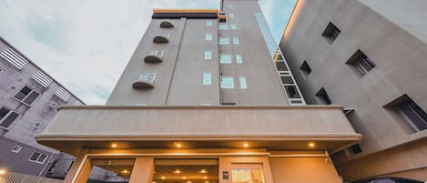 Una entrada de hotel moderna con zona de estacionamiento para automóviles.