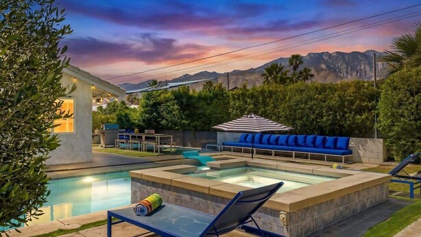 Ein Swimmingpool mit Whirlpool, Liegestühlen und einem überdachten Sitzbereich.