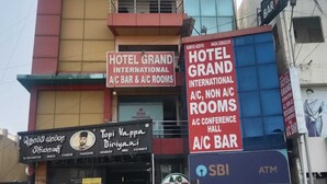 A multi-story building with signs for Hotel Grand International, A/C bar, and A/C rooms. - Hotel Grand International (Erode)