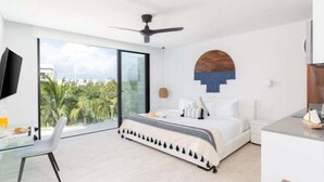 Une chambre à coucher moderne, avec un lit, un bureau et une grande fenêtre.