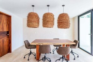 A conference room with a wooden table and six chairs, three hanging wicker pendant lights, and a large window. - B307 CPL, Increible Studio Jungle View (Tulum)