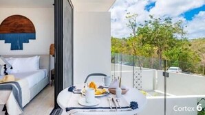 A modern hotel room with a bed, a dining table with breakfast, and a balcony with a view of trees and a car. - E209 CPL, Cowork / Piscina / Estilo (Tulum)