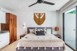 Ein modernes Schlafzimmer mit einem Bett, Nachttischen, einem Deckenventilator und einem großen Fenster.