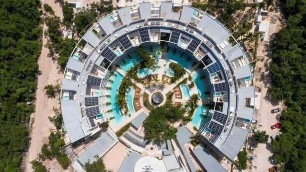 A circular hotel with a central swimming pool, surrounded by balconies and solar panels. - A107 CPL, Magnifico Studio Garden Jungle View (Tulum)