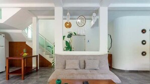 Un soggiorno moderno con divano, tavolino e oggetti decorativi.