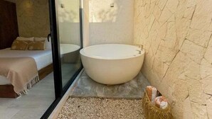 A modern bathroom with a freestanding bathtub, a glass shower enclosure, and a bed with a view of the outdoors. - Dk Jade 3, Your Exclusive Refuge in Tulum (Tulum)