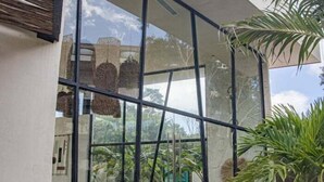A spacious indoor area with large glass windows, a variety of seating arrangements, and lush greenery. - Dk Jade 3, Your Exclusive Refuge in Tulum (Tulum)