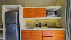 Uma cozinha compacta com geladeira, micro-ondas e armários de madeira.