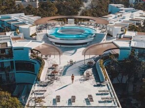 A modern hotel with a central swimming pool, sun loungers, and a covered seating area. - PH8C PANOR, Luxury Penthouse Alberca Privada (Tulum)
