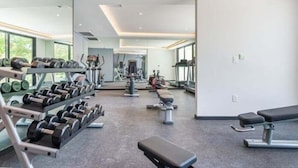 A modern gym with various exercise equipment, including dumbbells, benches, and cardio machines. - A107 CPL, Magnifico Studio Garden Jungle View-2 (Tulum)