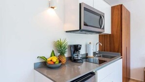 A modern kitchen with a microwave, coffee maker, and fruit bowl. - A201 CPL, Spectacular Studio Jungle View-2 (Tulum)