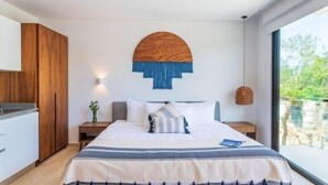 A modern bedroom with a large bed, wooden wardrobe, and a view of greenery outside. - A201 CPL, Spectacular Studio Jungle View-2 (Tulum)
