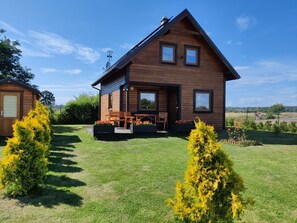 Ein Holzhaus mit Veranda, zwei Fenstern und einer Satellitenschüssel.
