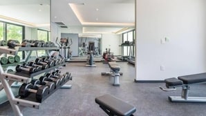 Et moderne fitnesscenter med vægtstativer, håndvægte og træningsudstyr.