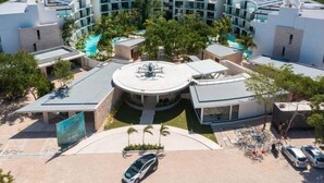 Un hotel moderno con un cortile centrale circolare, numerosi balconi e una piscina.