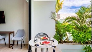 Ein Balkon mit Tisch für zwei Personen, einem Stuhl und einem Fernseher an der Wand.