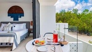 A bedroom with a bed, bedside table, and a balcony with a table set for breakfast. - E203 CPL, Cowork /Gym/Estilo moderno / Jardín-2 (Tulum)
