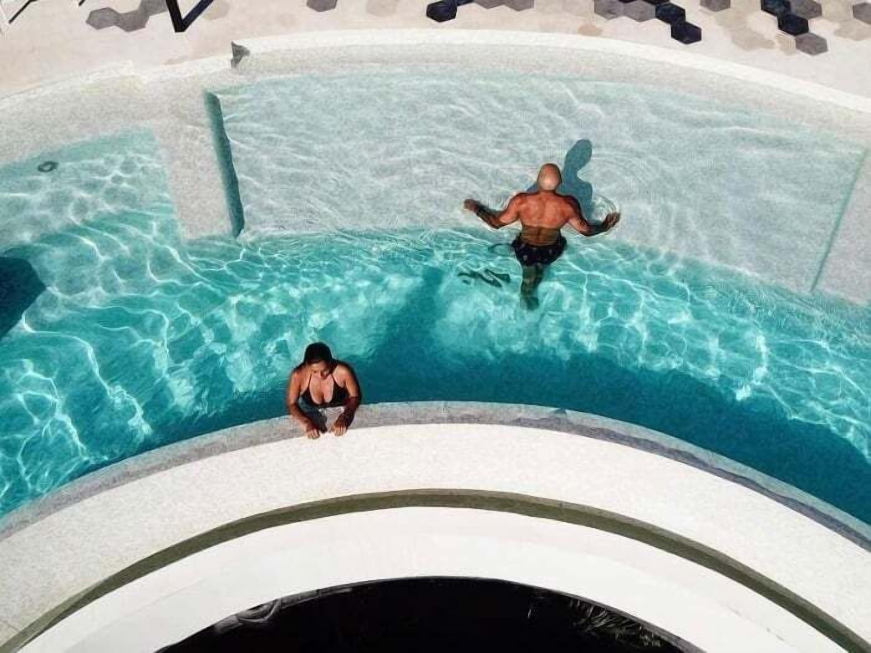 Una piscina con agua cristalina y borde curvo.