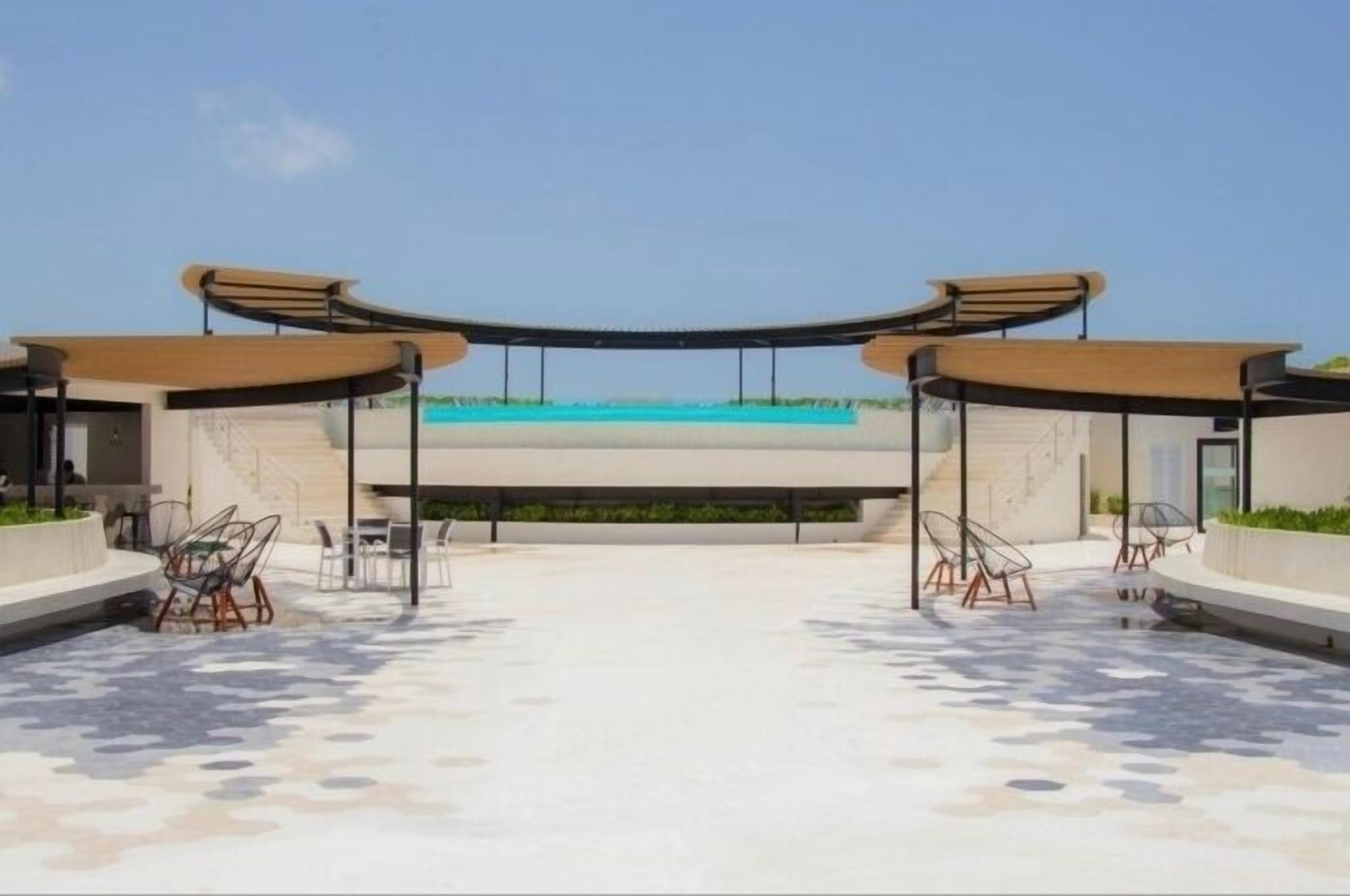 Une terrasse sur le toit dotée d’une piscine, d’un espace salon extérieur et d’une architecture moderne.