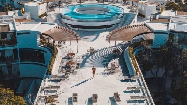 A rooftop swimming pool with sun loungers and a covered seating area, surrounded by modern buildings. - 207D PANOR, Luxury Apartment Alberca 360°-2 (Tulum)