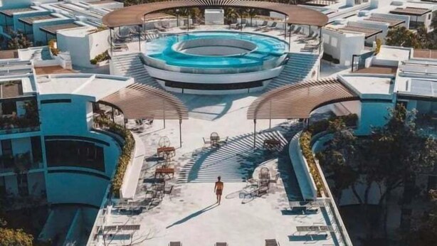A modern hotel with a central swimming pool, sun loungers, and a covered seating area. - PH8C PANOR, Luxury Penthouse Alberca Privada-2 (Tulum)
