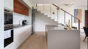 A modern kitchen with white cabinetry, a built-in oven, and a central island. - PH7B PANOR, Private Paradise in Tulum-2 (Tulum)
