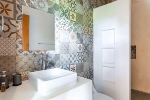 A modern bathroom with a white sink, a mirror, and patterned tiles on the walls. - VISCOUNT III, New and Big Apartment-2 (Tulum)