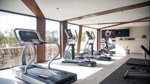 A gym with treadmills and elliptical machines, large windows, and a modern interior design. - Dk Jade 3, Your Exclusive Refuge in Tulum-2 (Tulum)