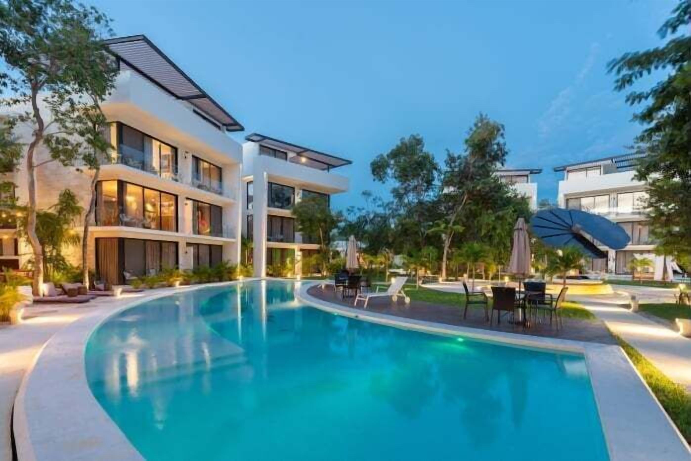 Un hôtel moderne doté d’une piscine, d’un espace extérieur aménagé et d’un jardin bien entretenu.