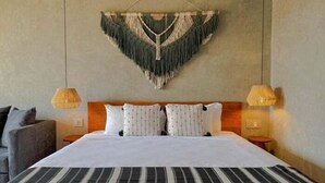 A hotel room with a large bed, two bedside lamps, a headboard, and a wall hanging above the bed. - SEREMONIA 206, Tu Refugio Ideal-2 (Tulum)