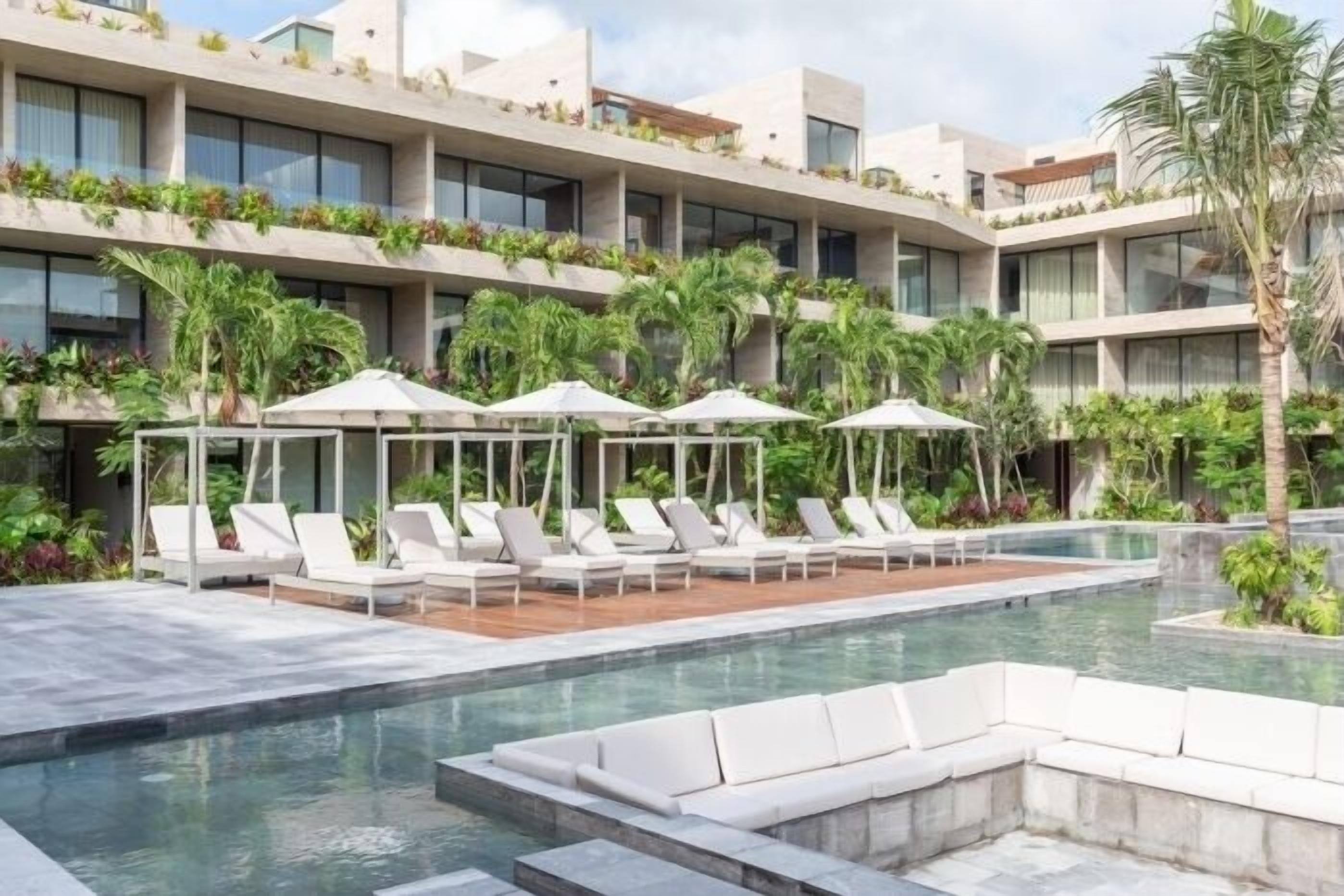 Un hôtel moderne doté d’une piscine, de chaises longues et d’un jardin sur le toit.