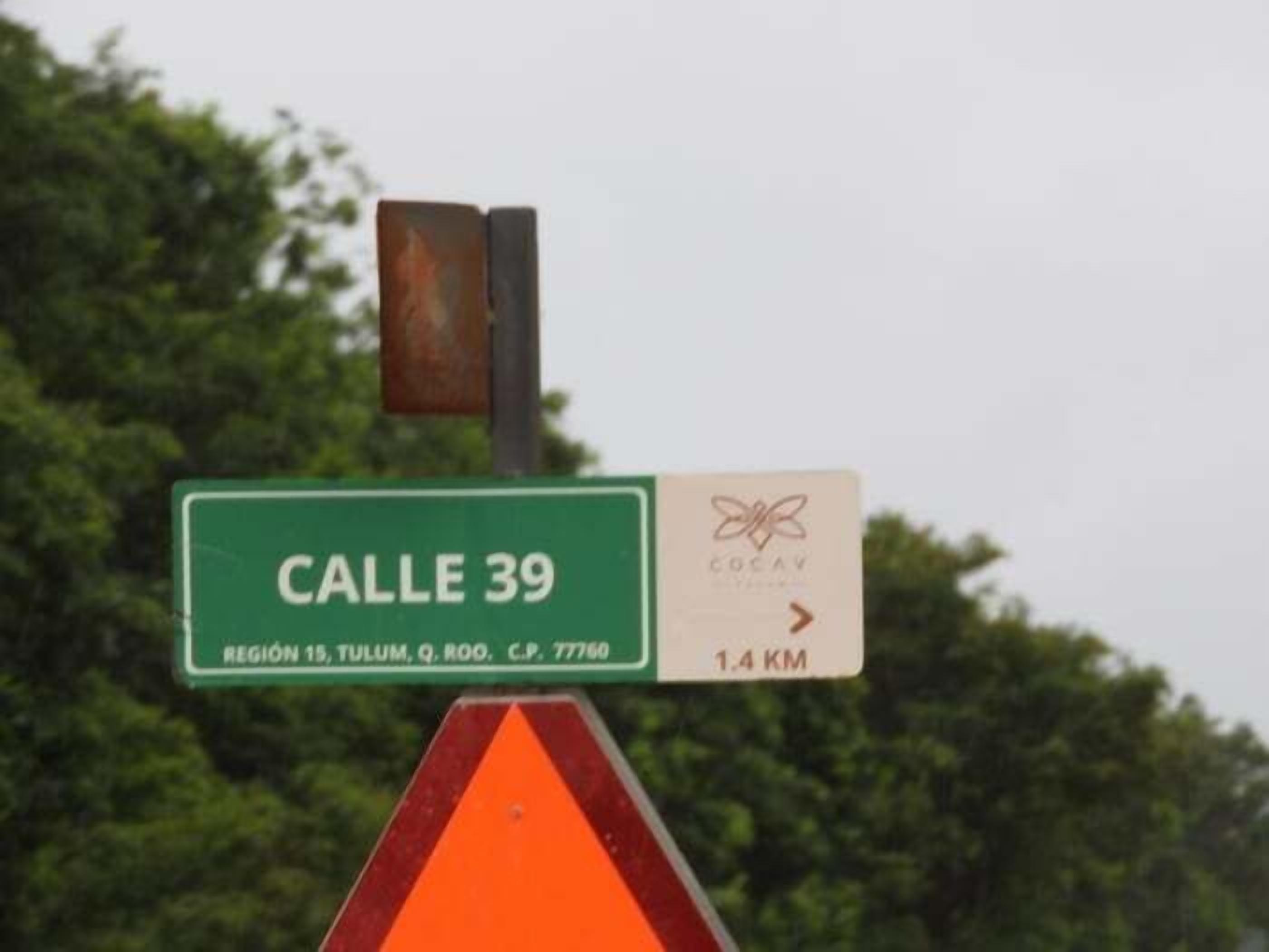 A street sign for Calle 39 with a distance marker of 1.4 KM.