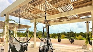 A covered outdoor area with multiple hammocks suspended from the ceiling. - COCAY 210, Studio Premium Pet and Amenities (Tulum)