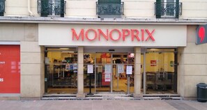 A Monoprix store with large glass windows and a red sign. - The Corail - Refined - La Défense by MonPetitFaré (Puteaux)