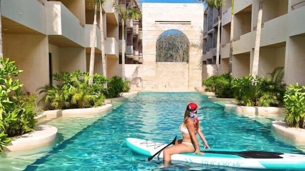 Ein Schwimmbad mit einer Person auf einem Stand-Up-Paddleboard.