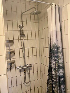A shower with a rain showerhead, a handheld showerhead, and a curtain with a forest pattern. - Summer house Fauna Hou Hals 300 m from the sea (Hals)
