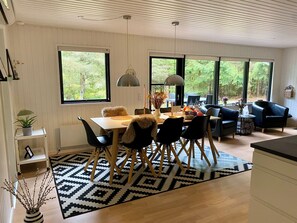 A modern dining area with a table, chairs, and a black and white patterned rug. - Summer house Fauna Hou Hals 300 m from the sea (Hals)